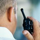 A security guard talking on two way radio
